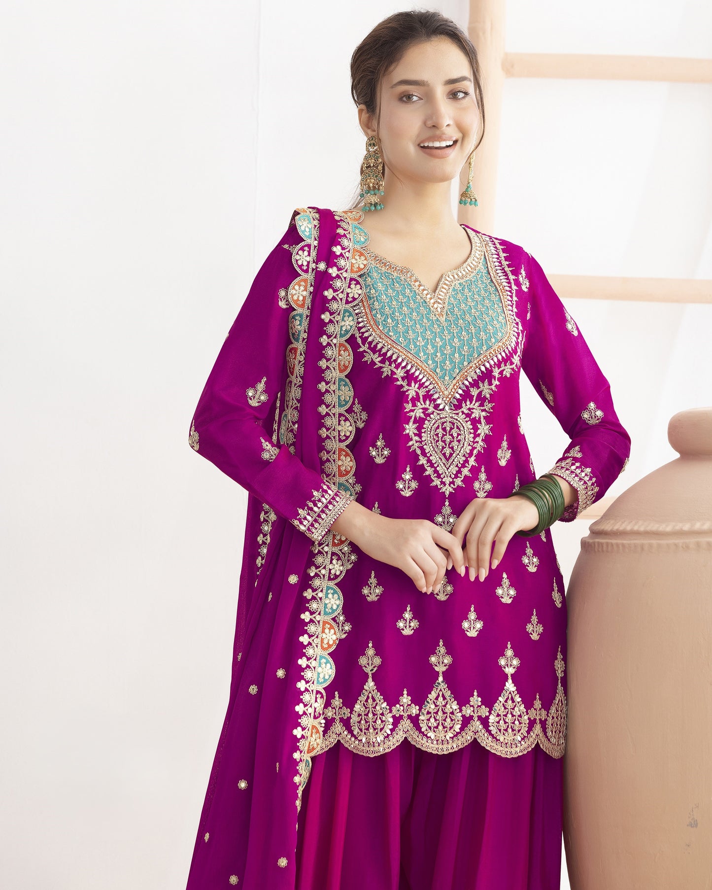 Woman wearing a purple embroidered traditional outfit with a white background