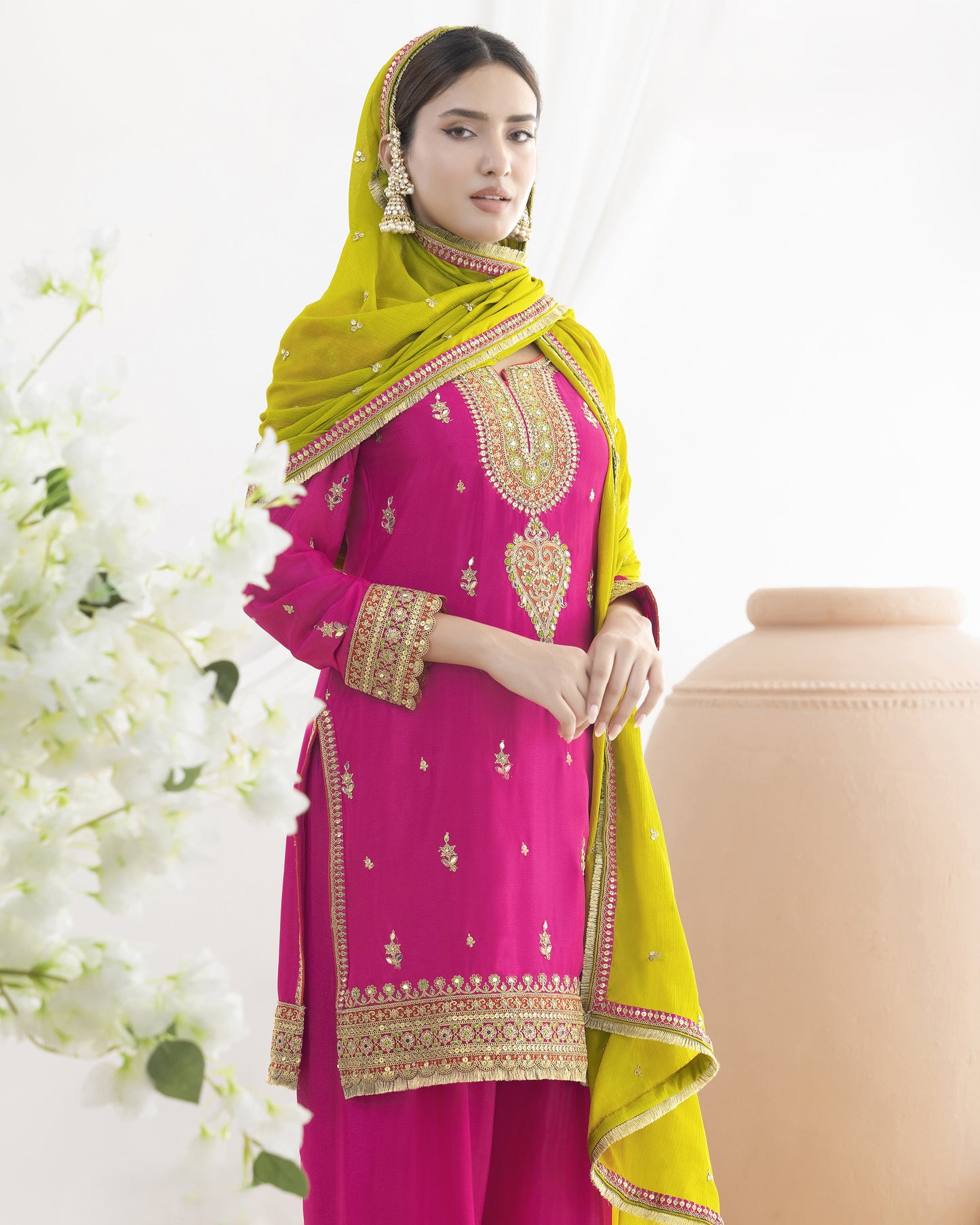 Woman wearing a pink and yellow traditional outfit with floral background