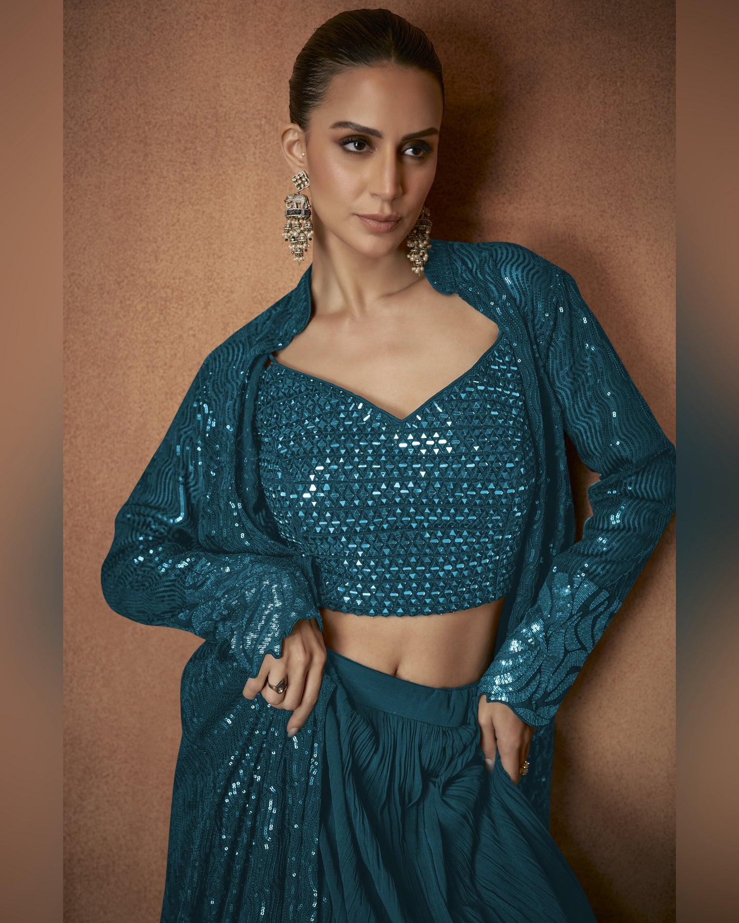 Woman wearing a teal sequin outfit against a brown background
