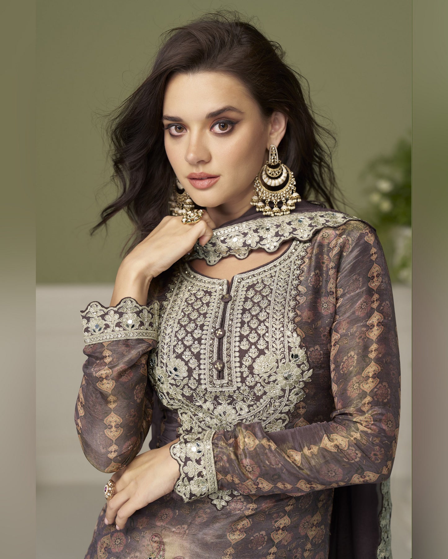 Woman wearing an ornate traditional outfit with intricate patterns and jewelry.