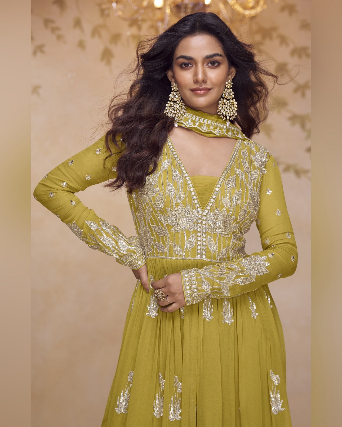 Woman wearing a green embroidered outfit with a beige background