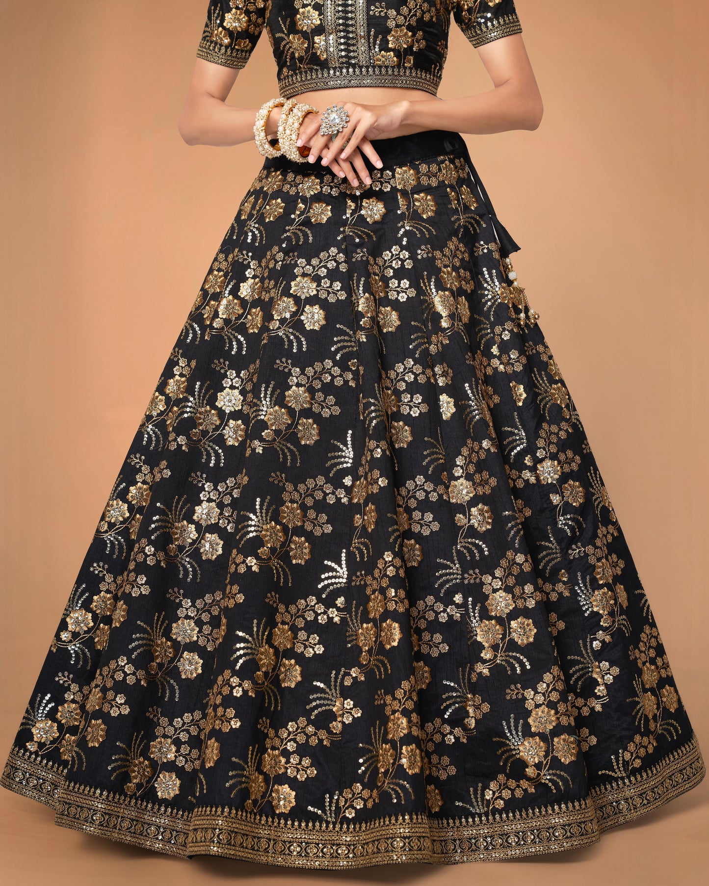 Black floral embroidered traditional outfit on a beige background
