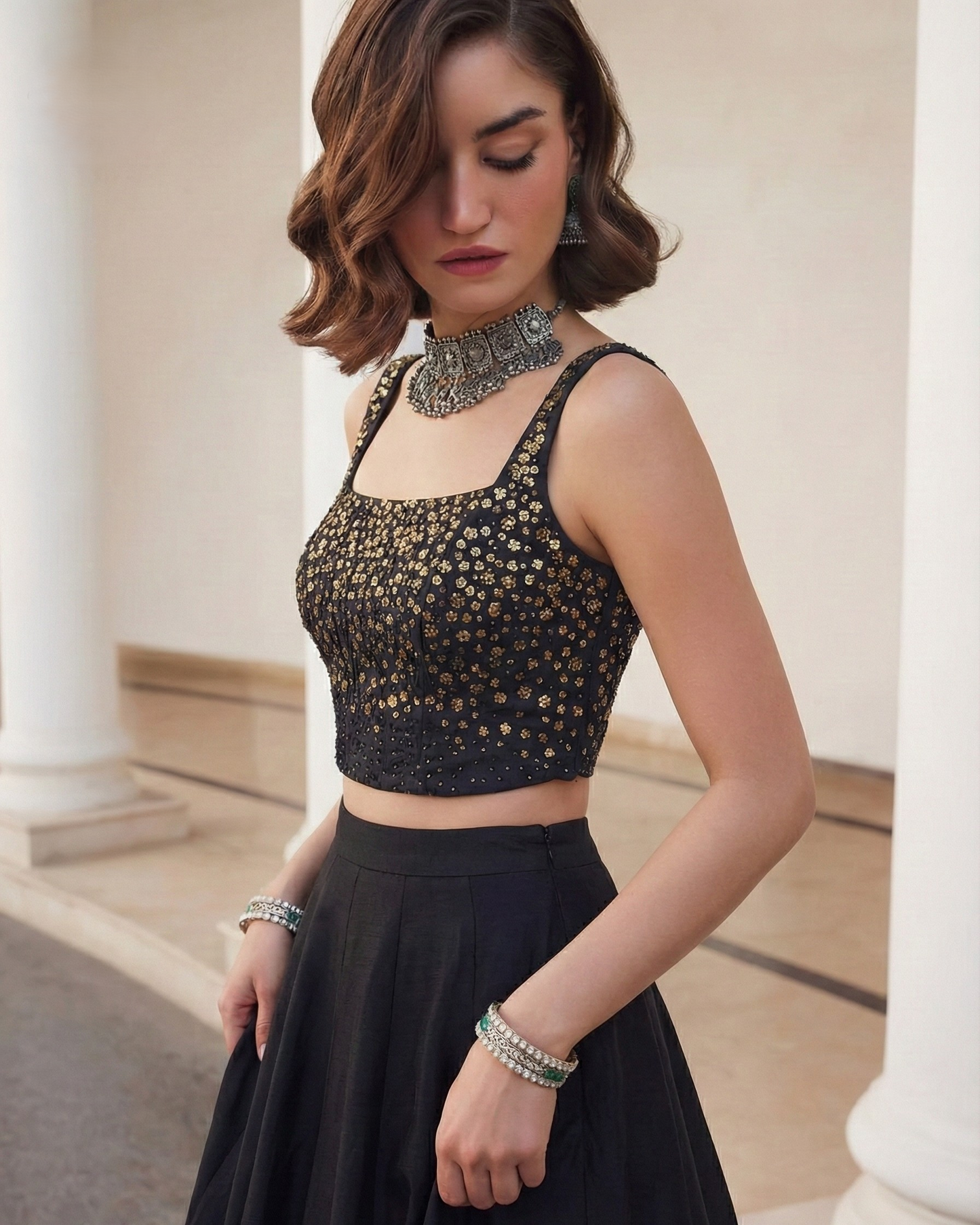 Woman wearing a black embellished top and skirt in an indoor setting