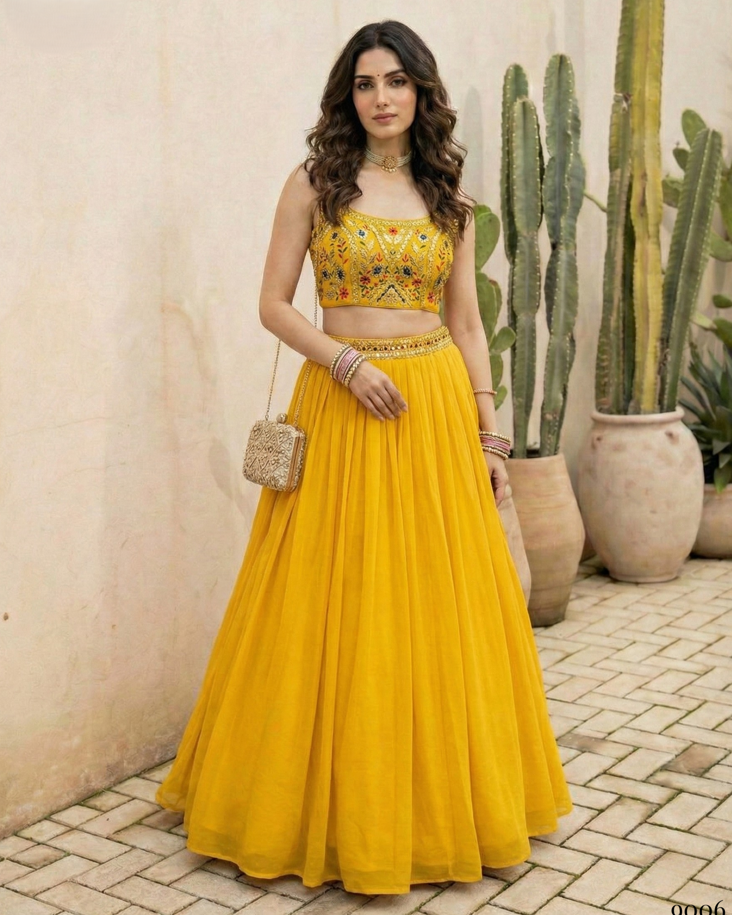 Woman in a yellow traditional outfit standing outdoors with plants in the background