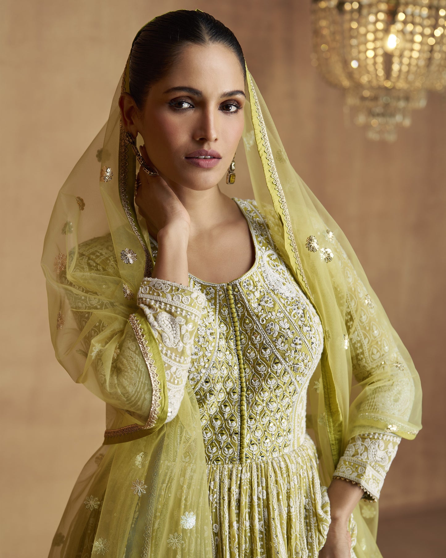 Woman wearing a yellow embroidered traditional outfit with a matching dupatta.