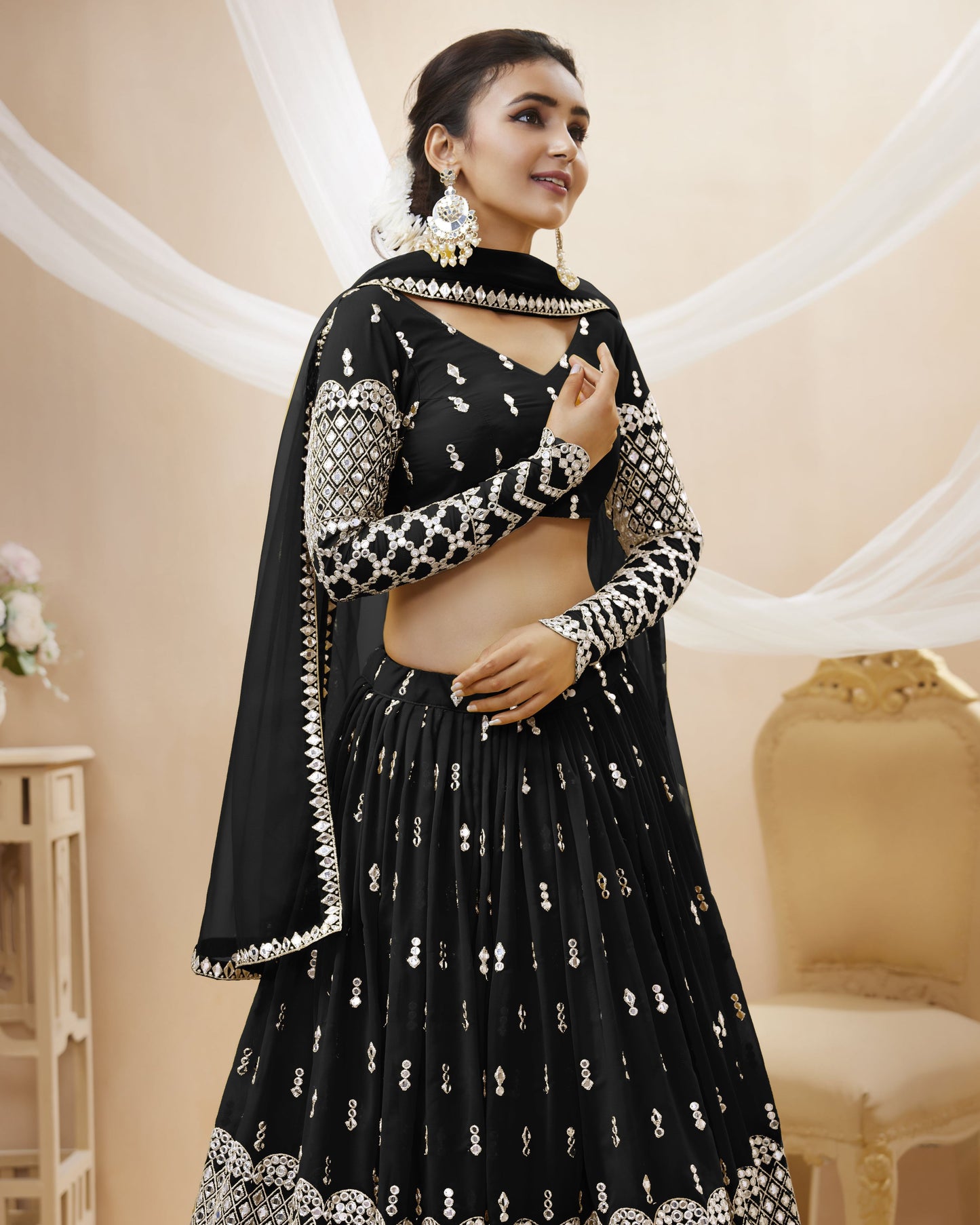 Woman wearing a black and white embroidered traditional outfit in an elegant indoor setting.