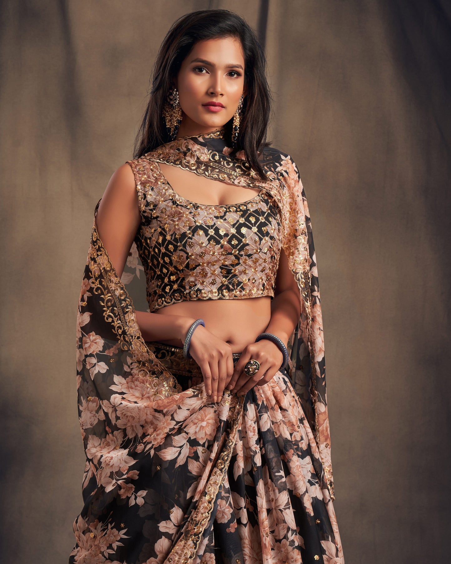 Woman wearing a floral saree with a brown background