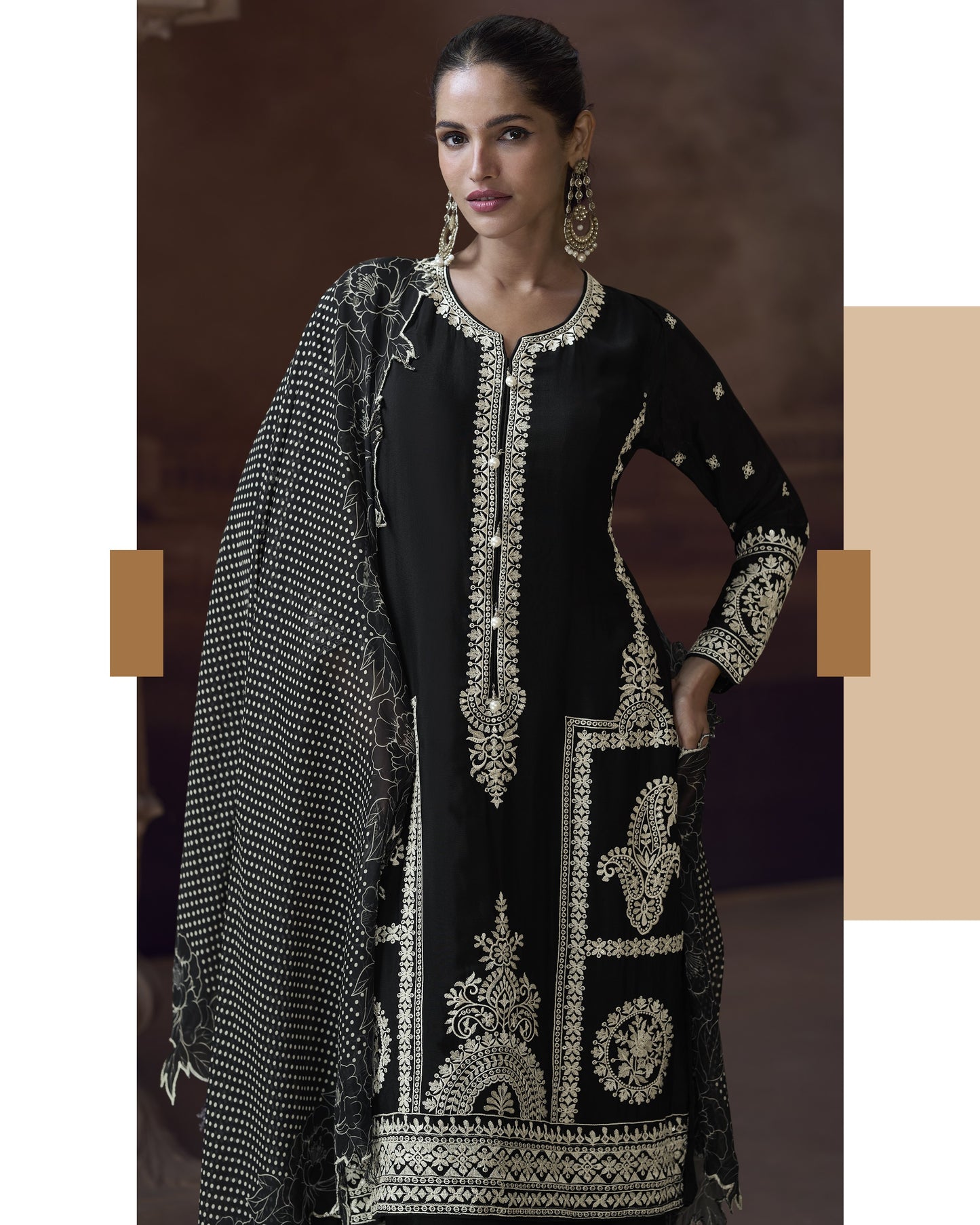 Woman wearing a black embroidered traditional outfit with a beige background