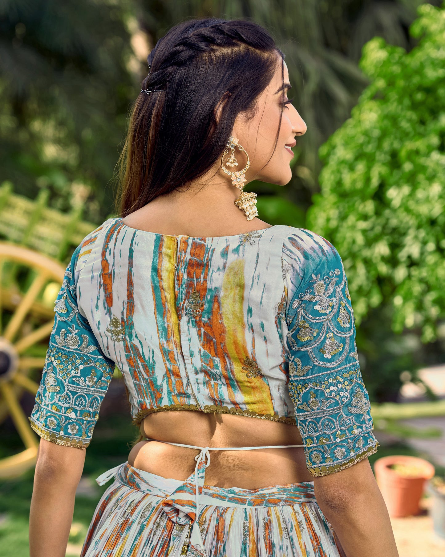 Woman wearing a colorful traditional outfit with a blurred green outdoor background