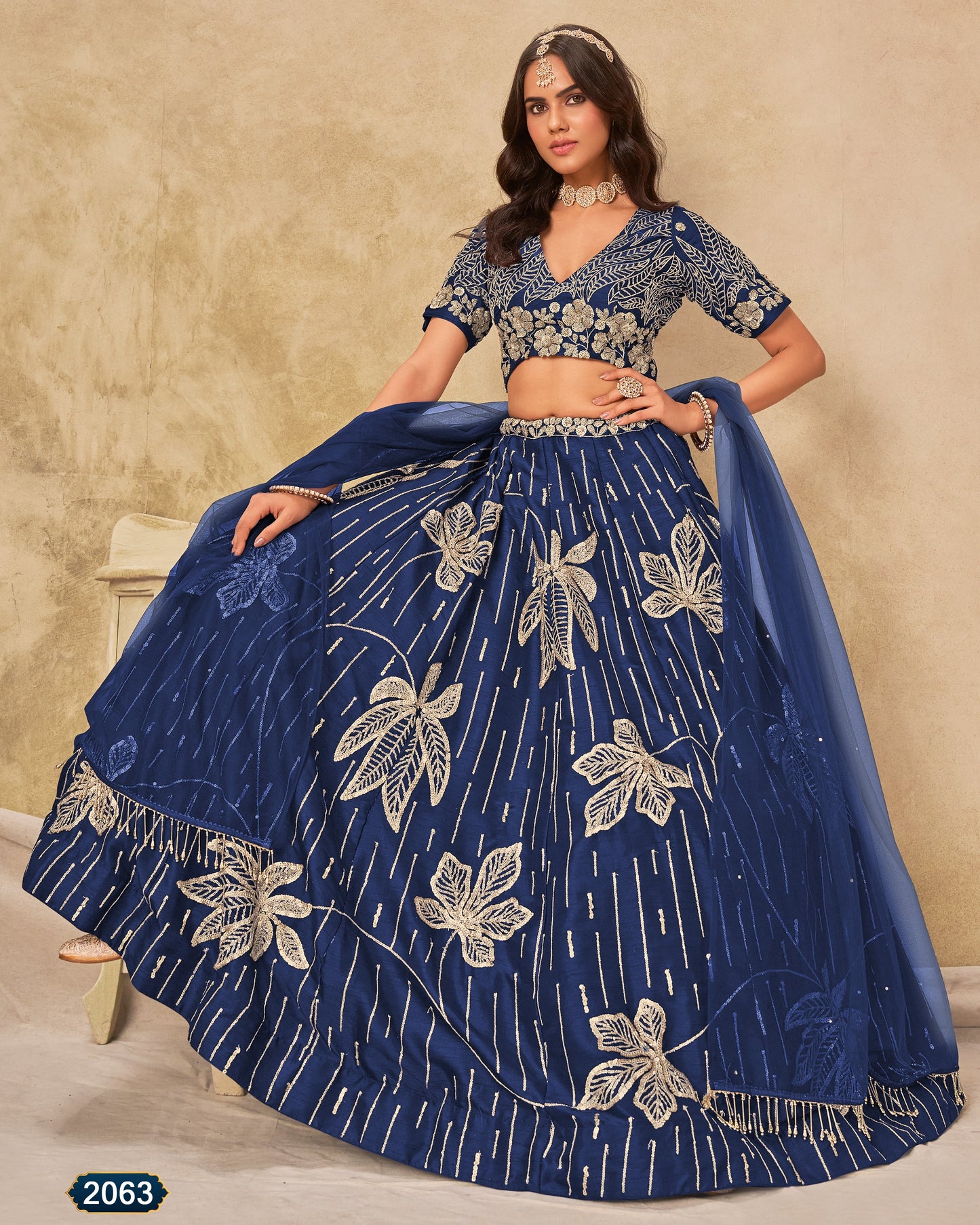 Woman wearing a blue embroidered traditional outfit with a beige background