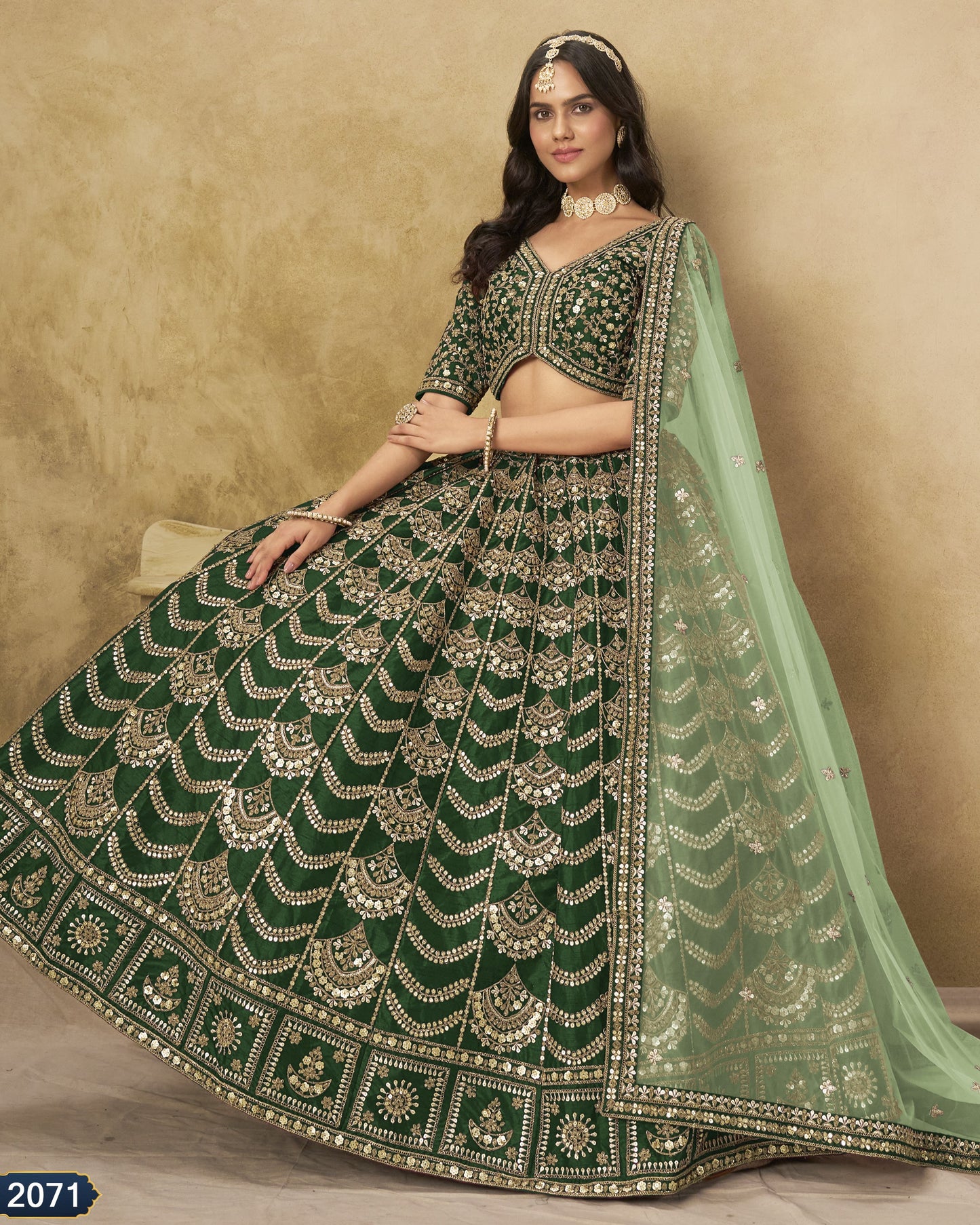 Woman wearing a green embroidered traditional outfit with a beige background