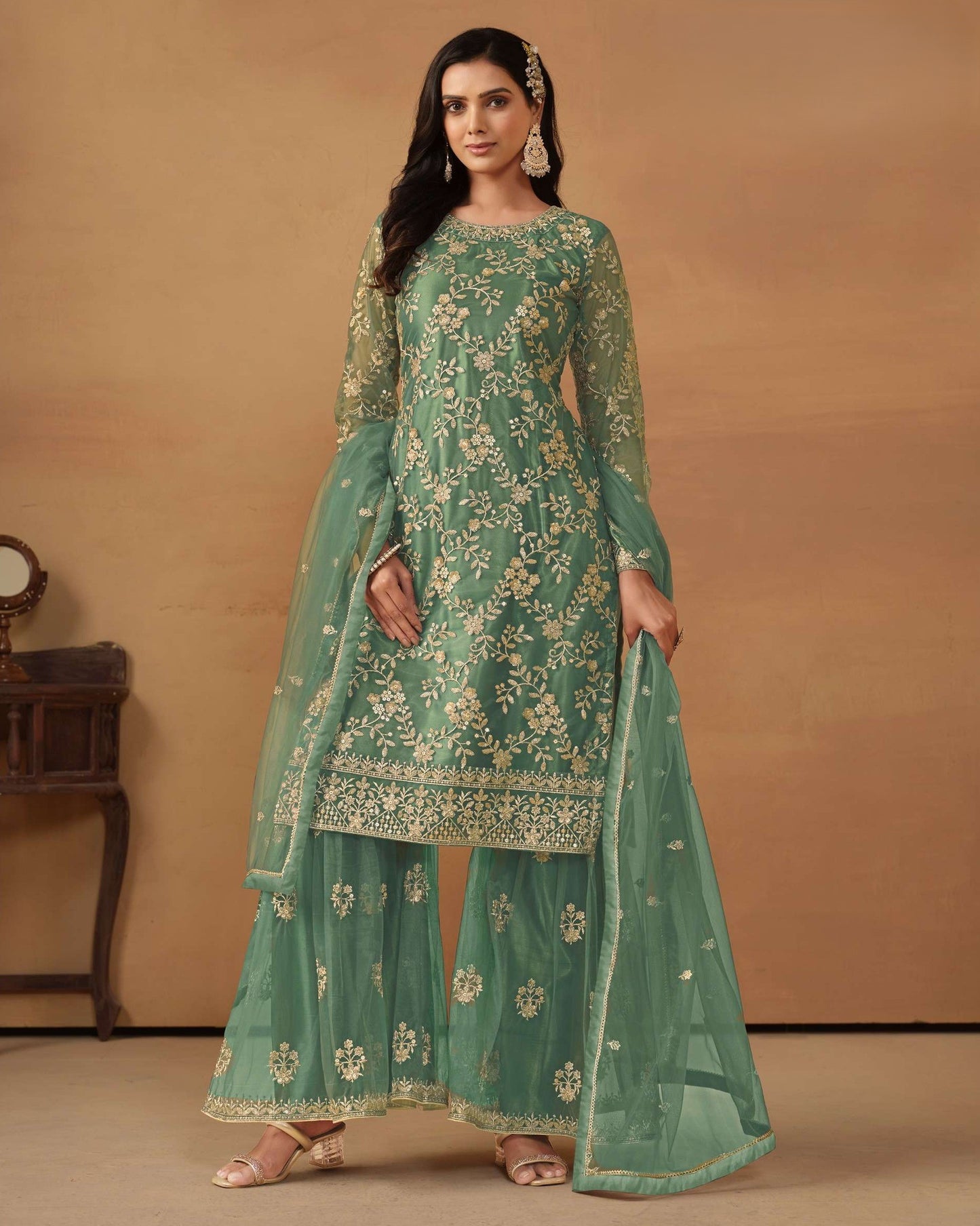 Woman wearing a green embroidered traditional outfit on a beige background