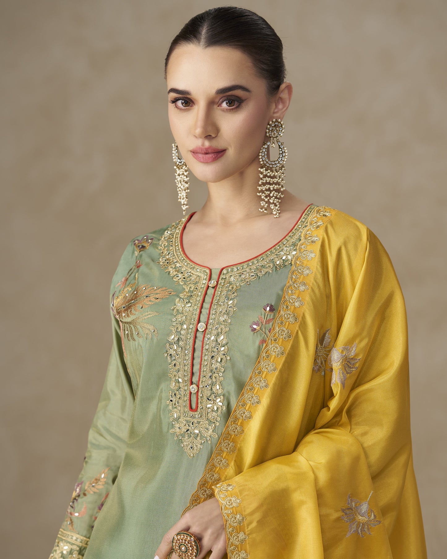 Woman wearing a traditional embroidered outfit with a beige background