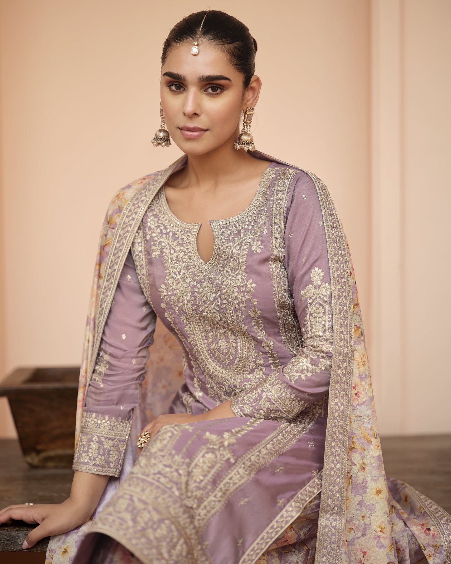 Woman wearing a traditional outfit with intricate patterns and embroidery.