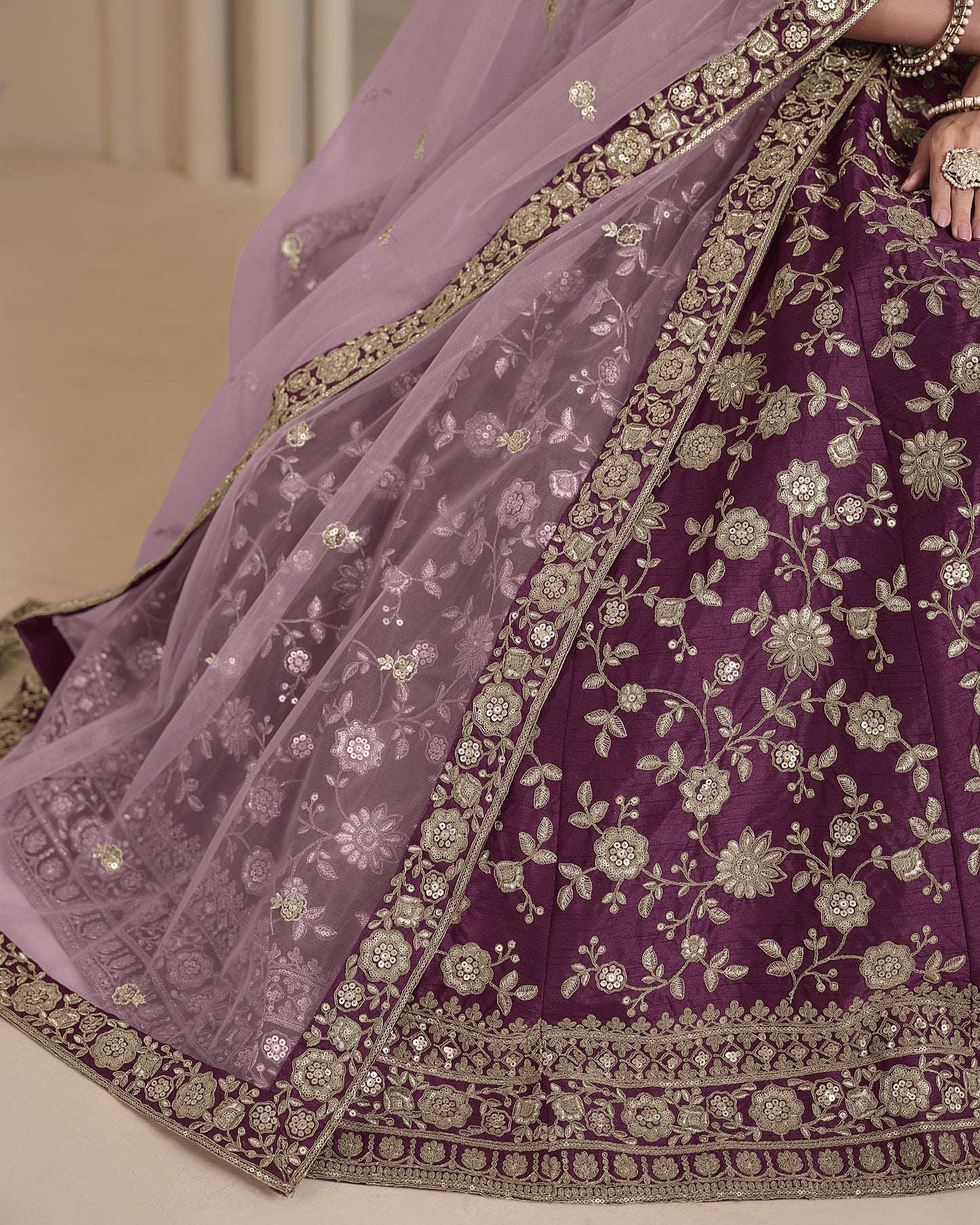Purple embroidered saree with gold detailing on a neutral background