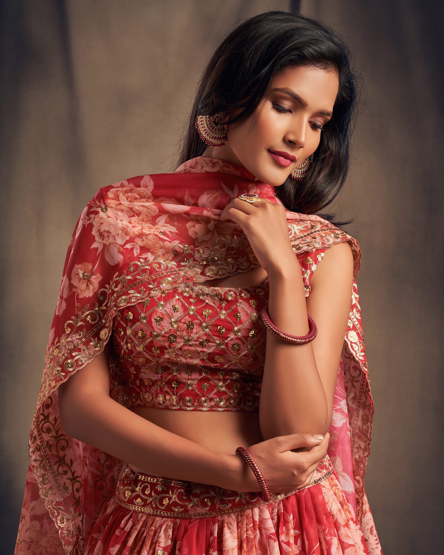 Woman wearing a red and gold traditional outfit with a plain background