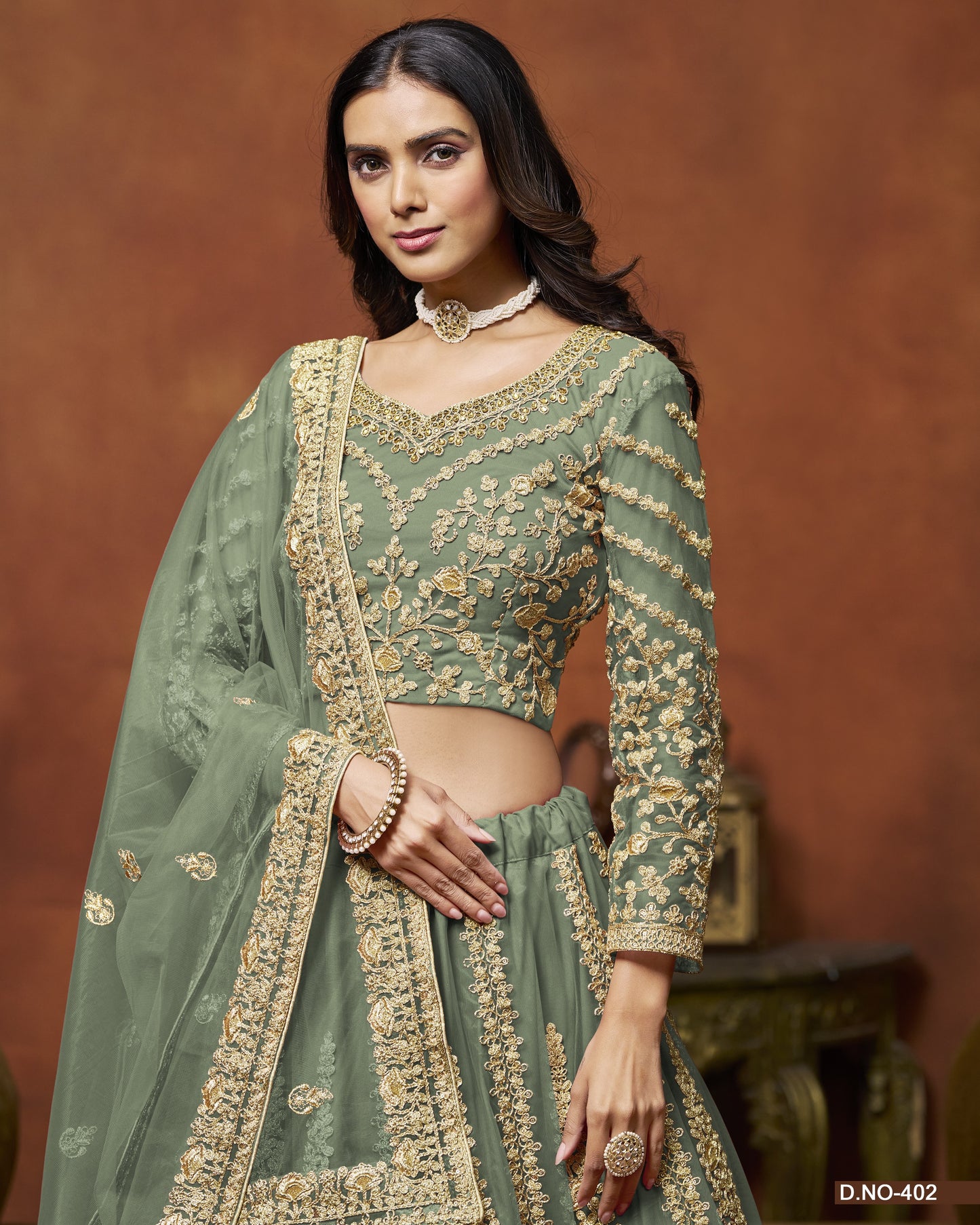 Woman wearing a green embroidered traditional outfit with a brown background