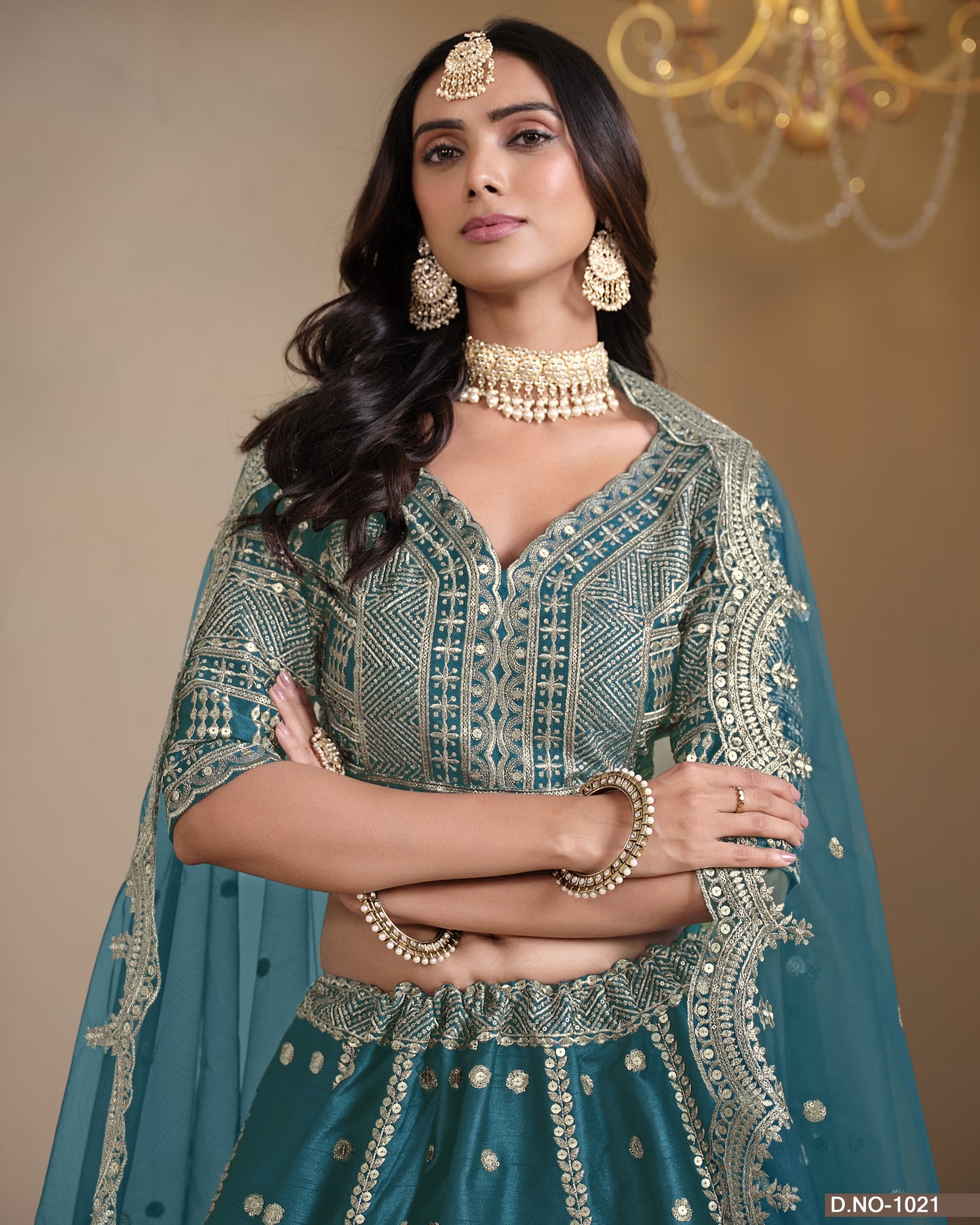 Woman in traditional attire with jewelry against a neutral background