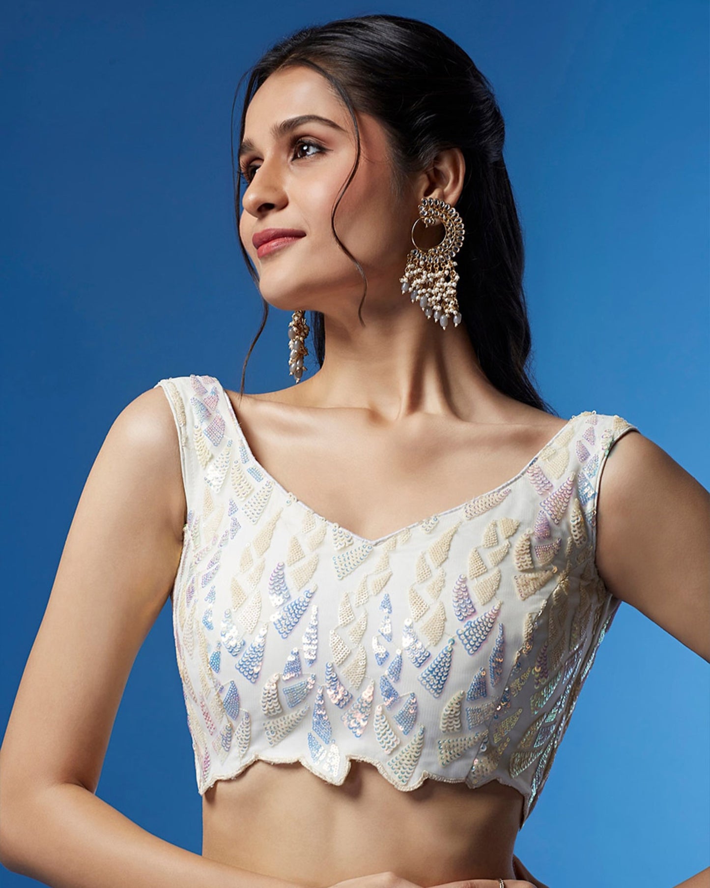 Woman wearing a decorative blouse against a blue background