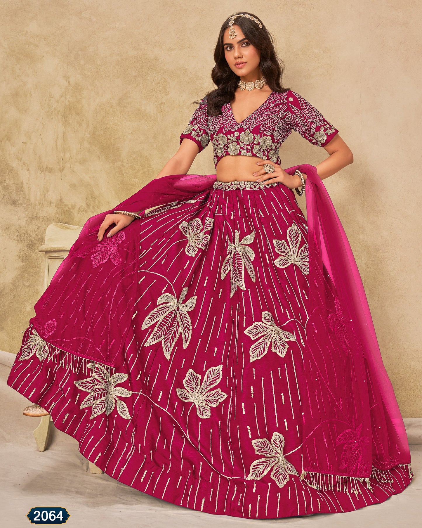 Woman wearing a pink traditional outfit with floral patterns on a beige background
