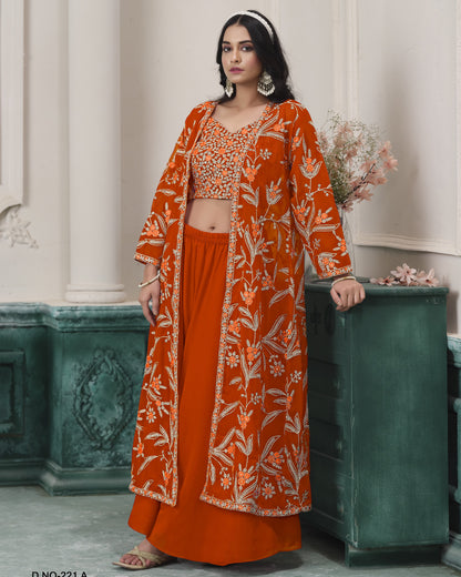 Woman wearing an orange floral outfit standing against a decorative wall.