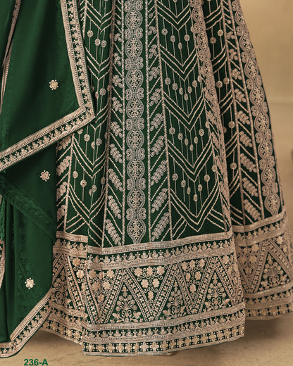 Green embroidered fabric with intricate white patterns on a beige background