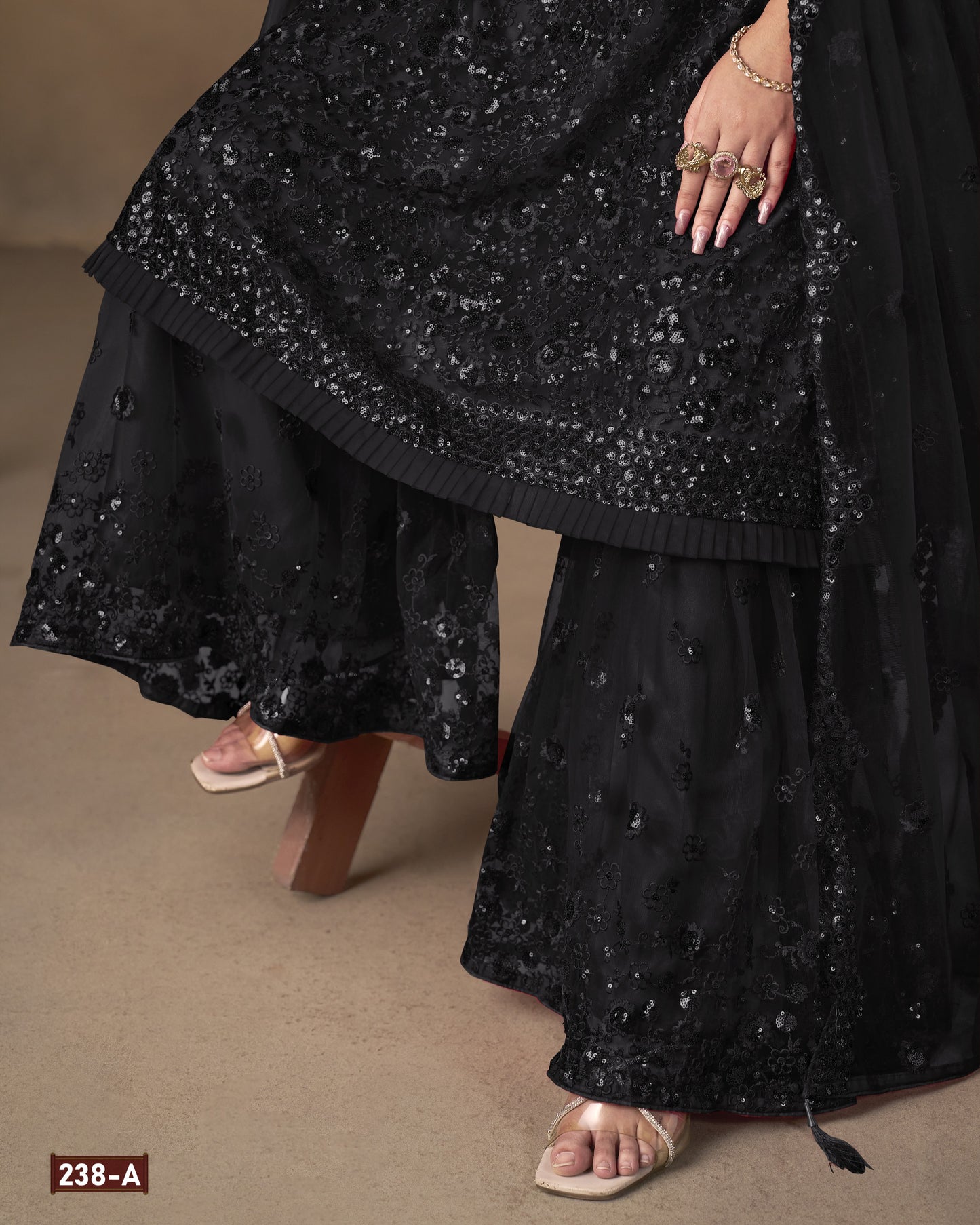 Black embroidered traditional outfit on a neutral background