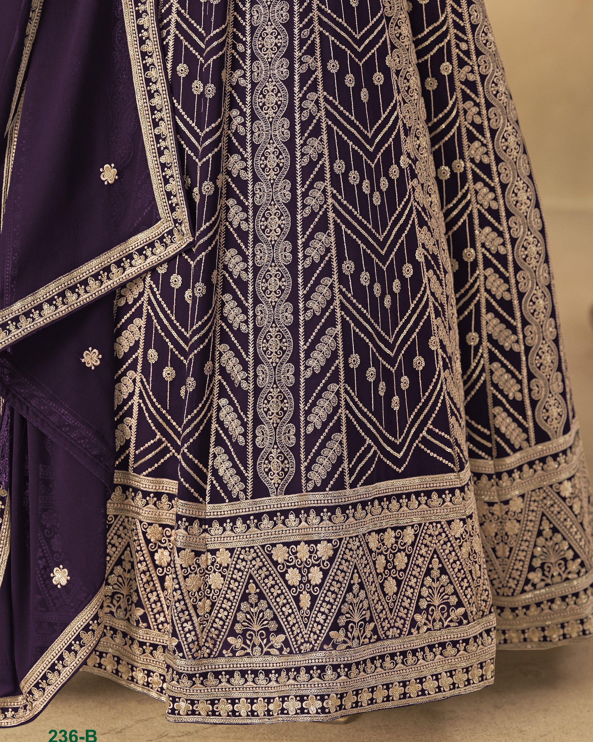 Navy blue fabric with intricate white embroidery on a beige background