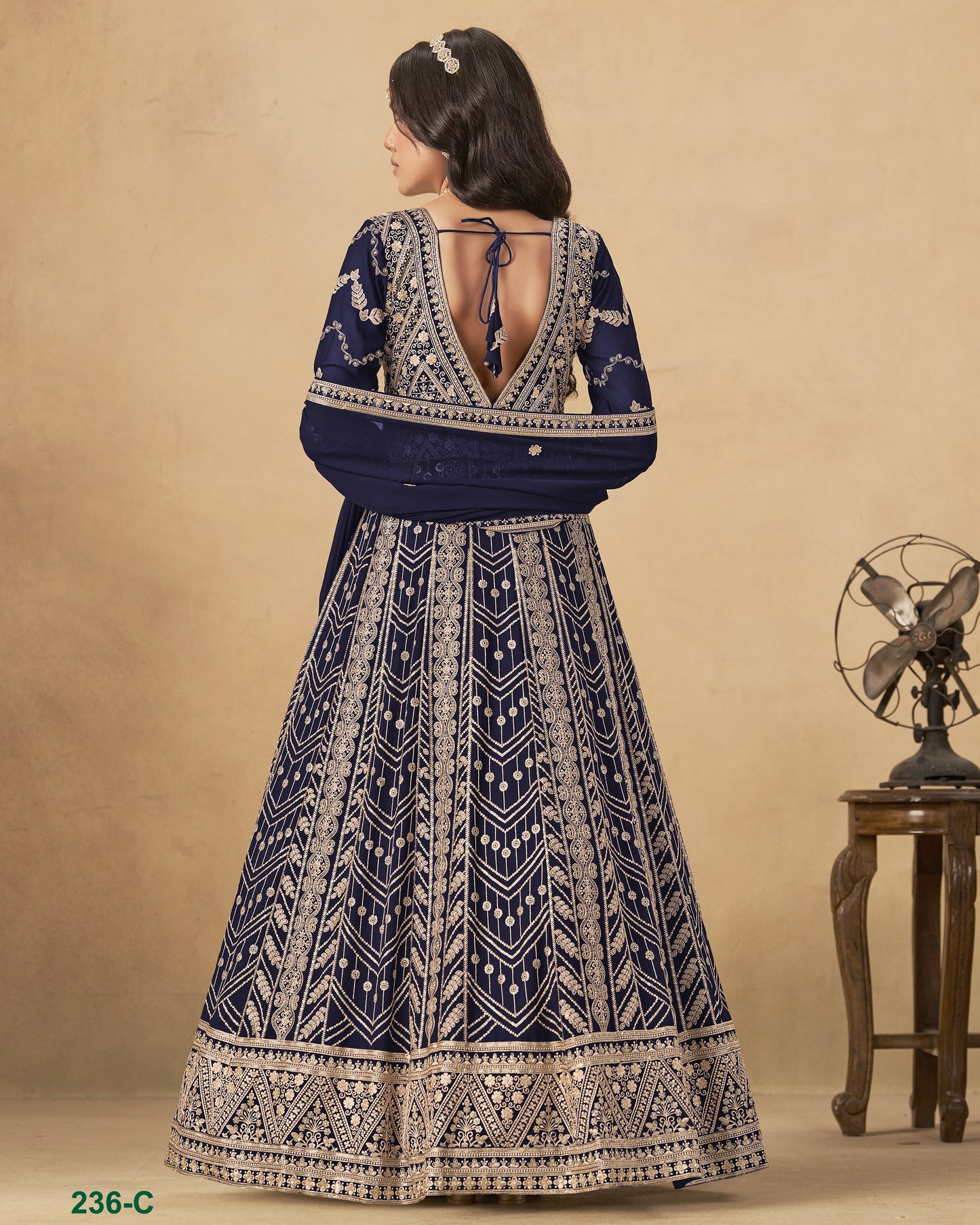 Woman wearing a blue and white patterned dress with a beige background