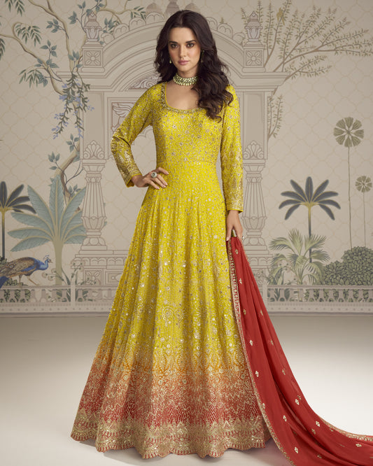 Woman wearing a yellow and red embroidered traditional outfit with a patterned wall in the background