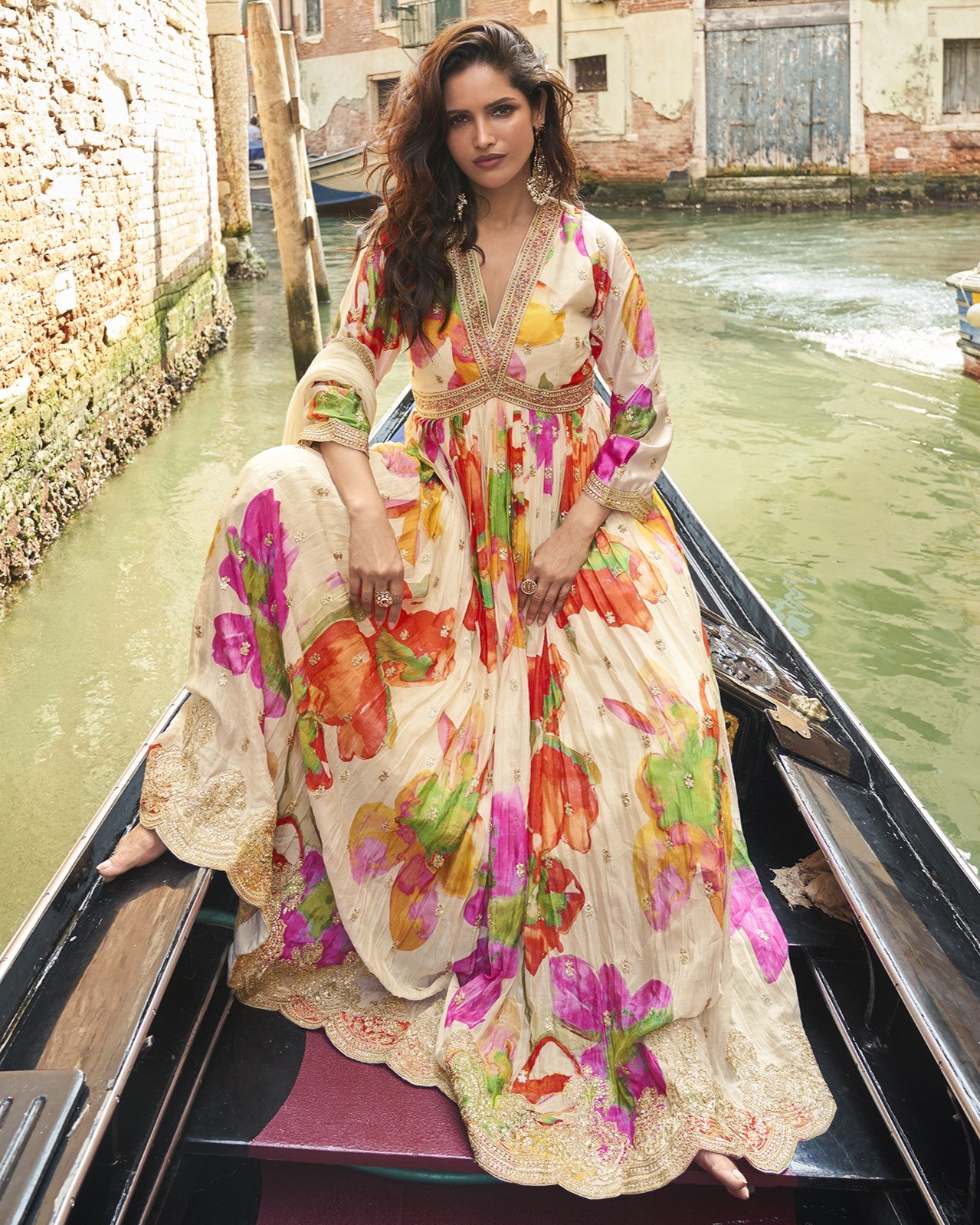 Woman in a colorful floral dress on a gondola in Venice