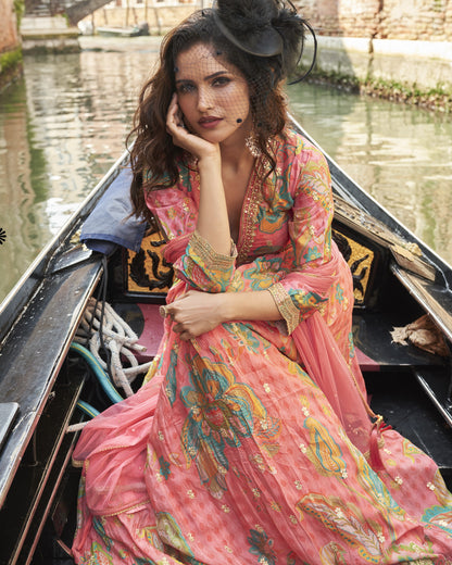 Woman in a colorful dress sitting in a gondola on a canal.