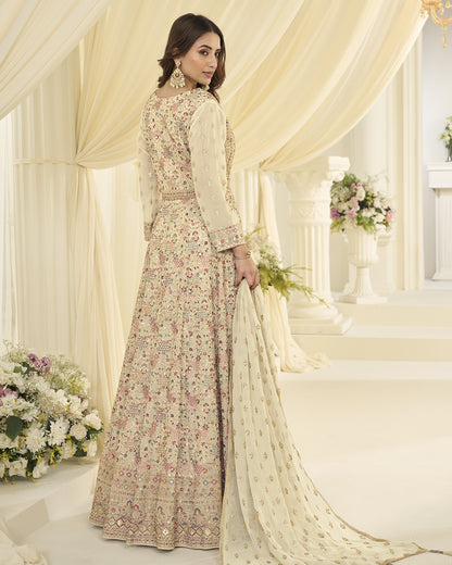 Woman in a floral dress standing in a decorated room with flowers and curtains.