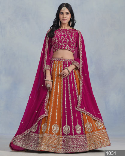Woman wearing a traditional pink and orange embroidered outfit with a matching dupatta on a light gray background.