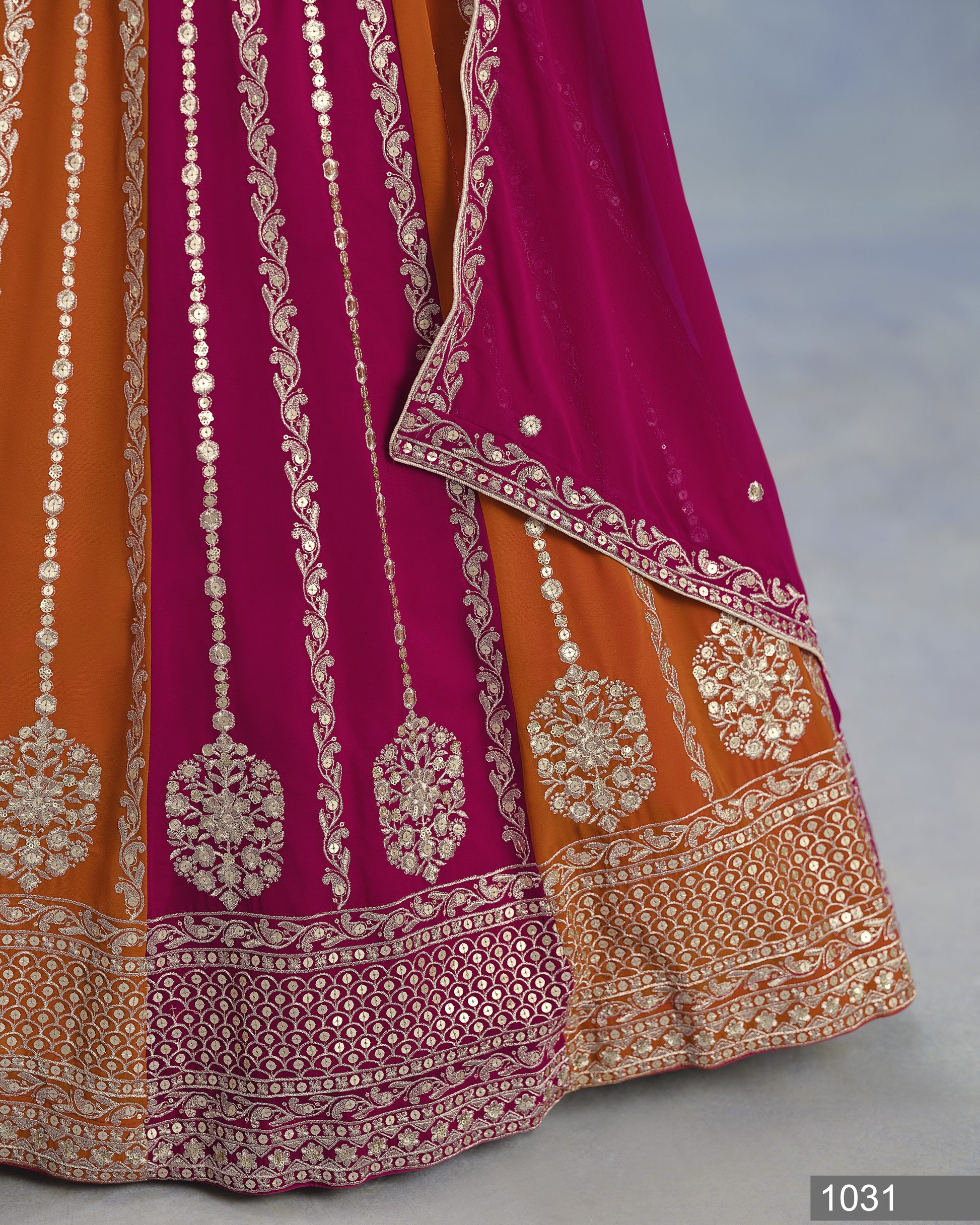 Traditional embroidered fabric with orange and purple colors on a gray background