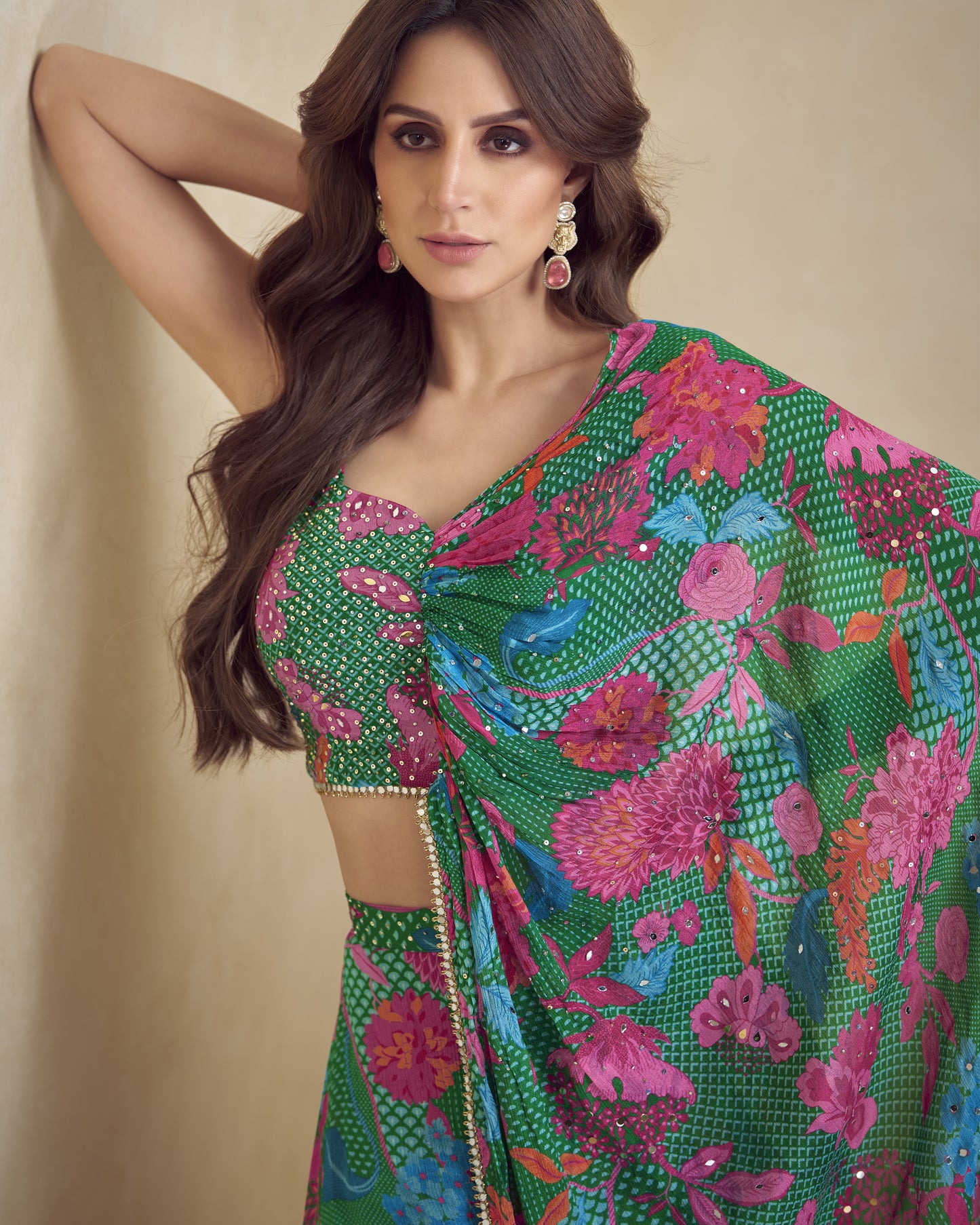 Woman wearing a colorful floral saree against a beige background
