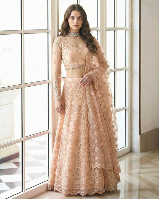 Woman wearing a peach lace outfit standing in front of large windows.