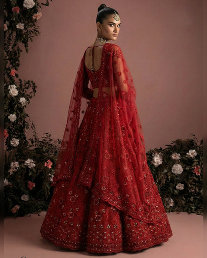 Red traditional outfit with floral decorations on a pink background