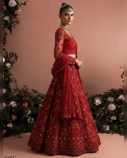 Red embroidered traditional outfit with floral decorations on a pink background