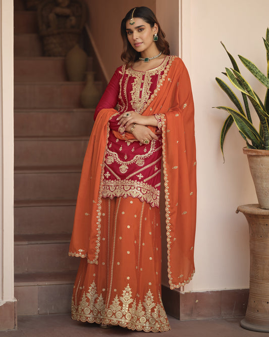Woman in traditional red and orange embroidered outfit standing indoors.