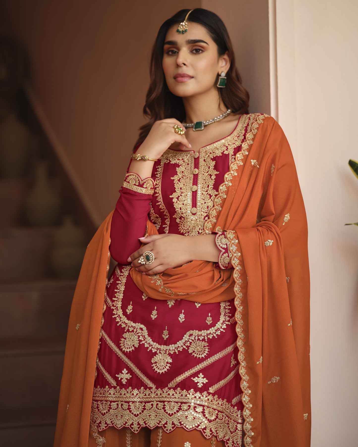 Woman wearing a traditional outfit with intricate designs in an indoor setting
