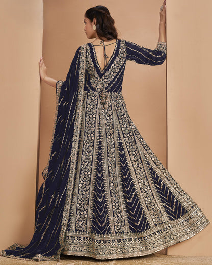 Navy blue and gold embroidered traditional outfit on a beige background