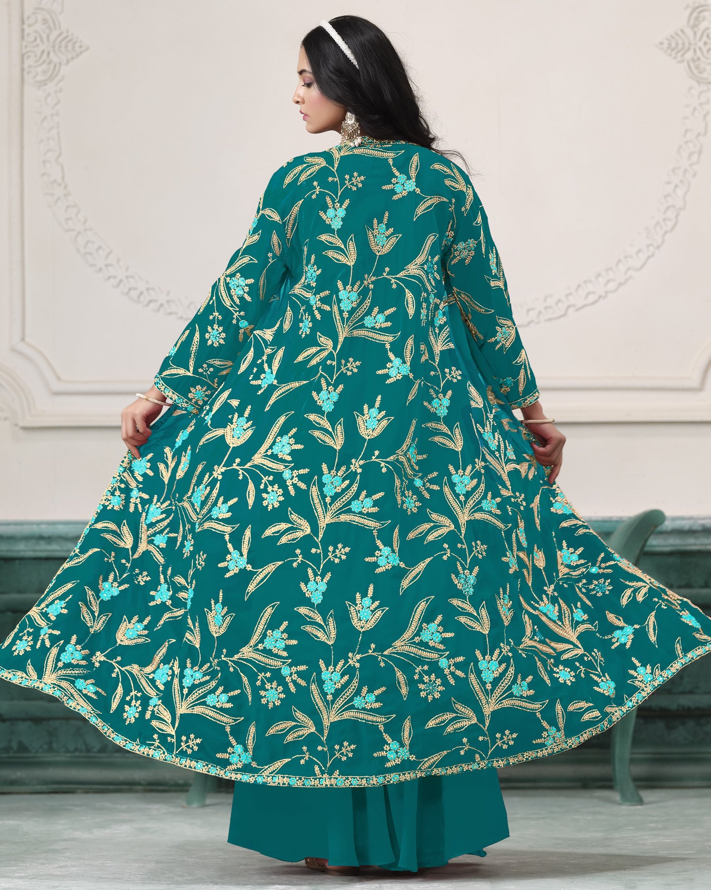 Woman wearing a teal floral dress with a white background