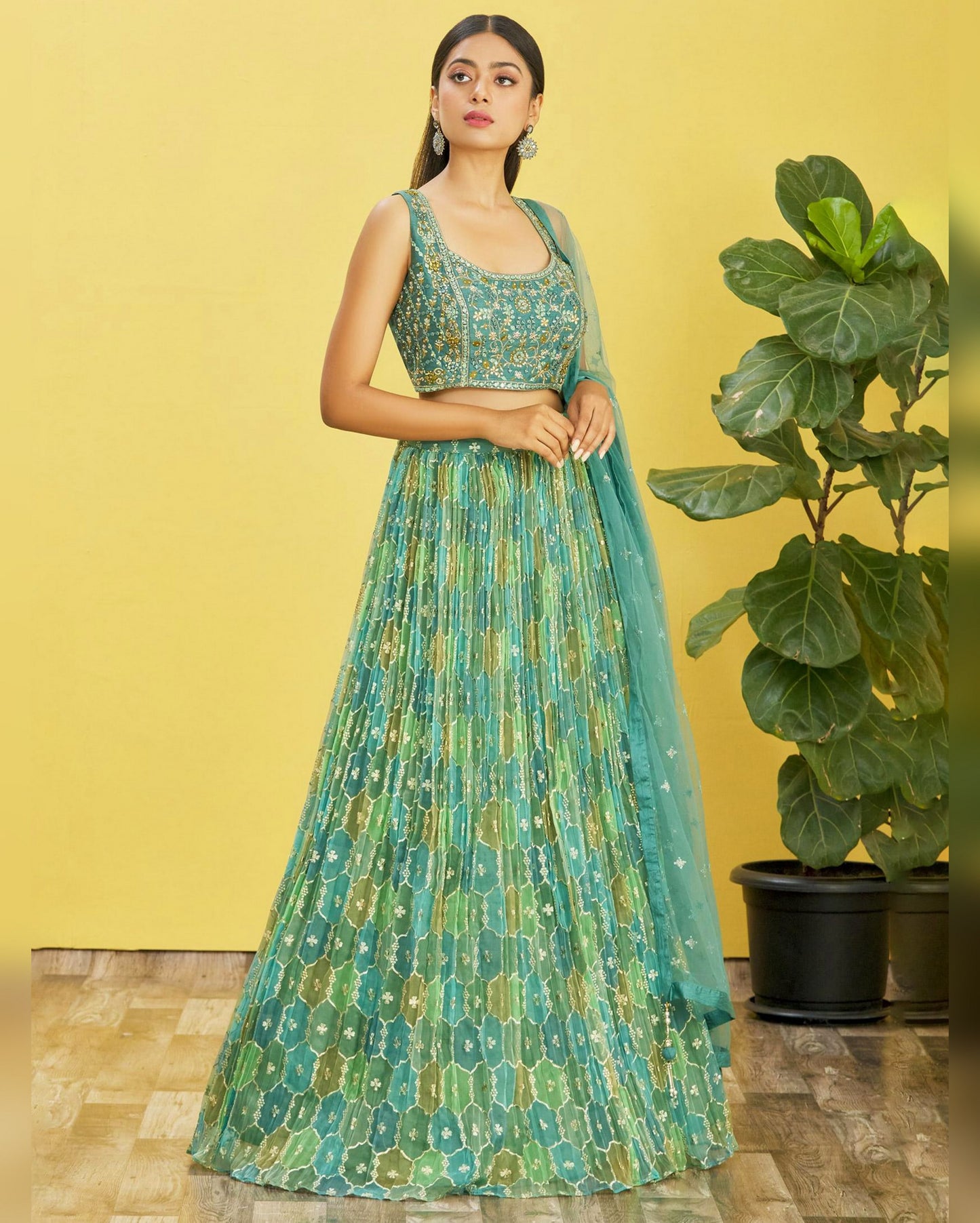 Woman wearing a green and blue patterned outfit with a yellow background