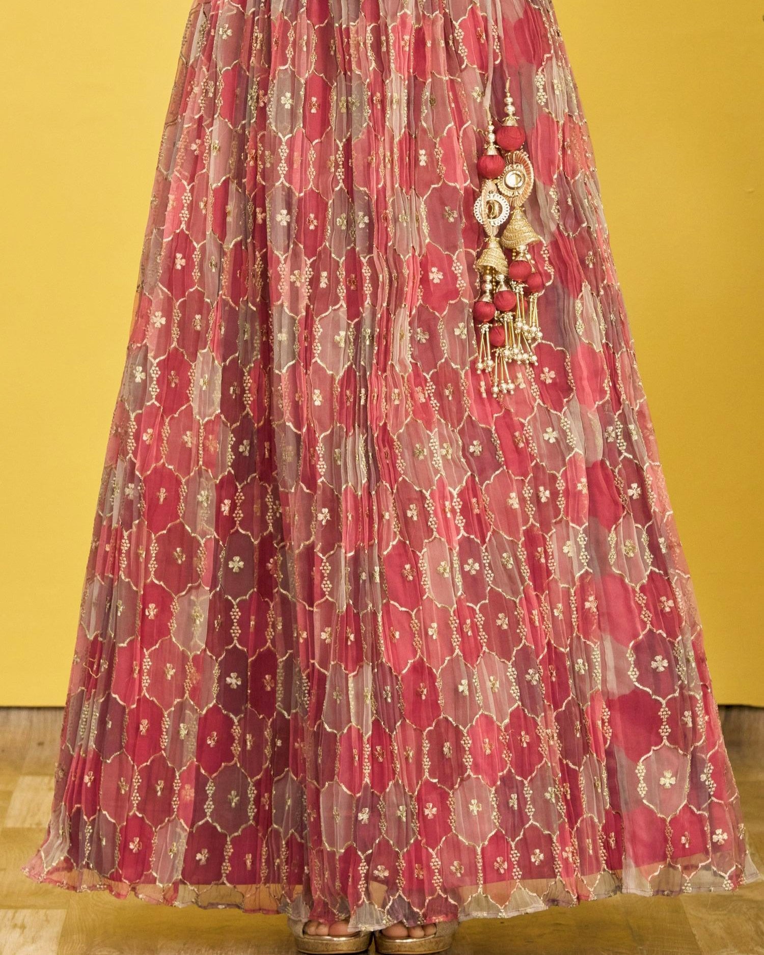 Red floral patterned skirt with decorative hanging elements on a yellow background