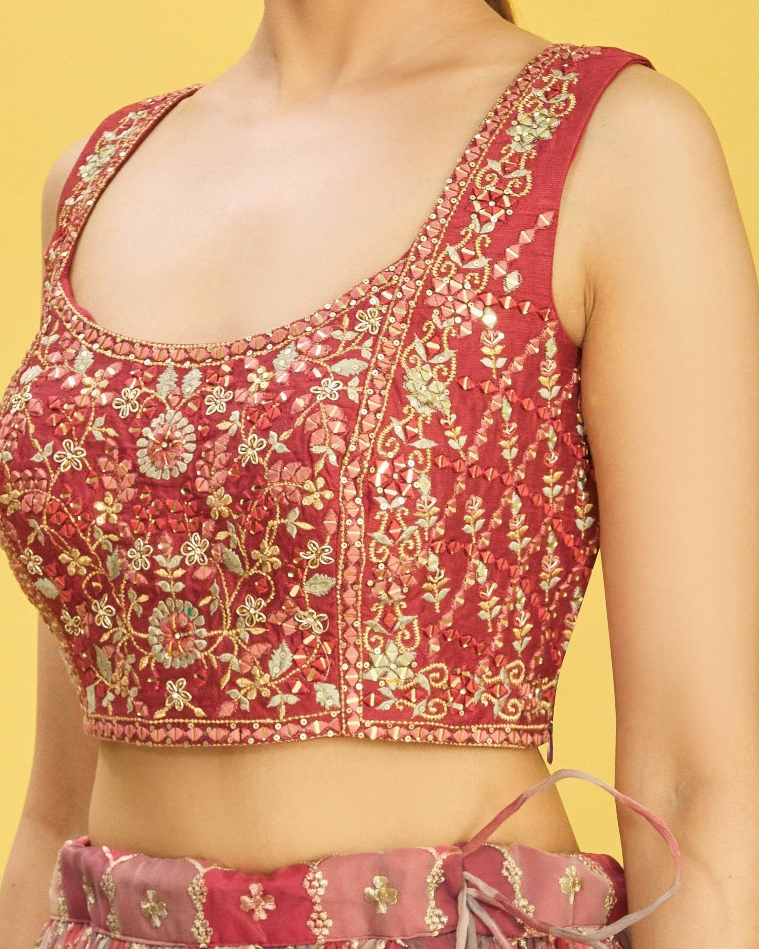 Red embroidered top with gold patterns on a yellow background