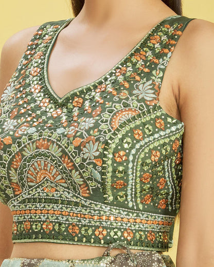 Green embroidered blouse with floral patterns on a neutral background