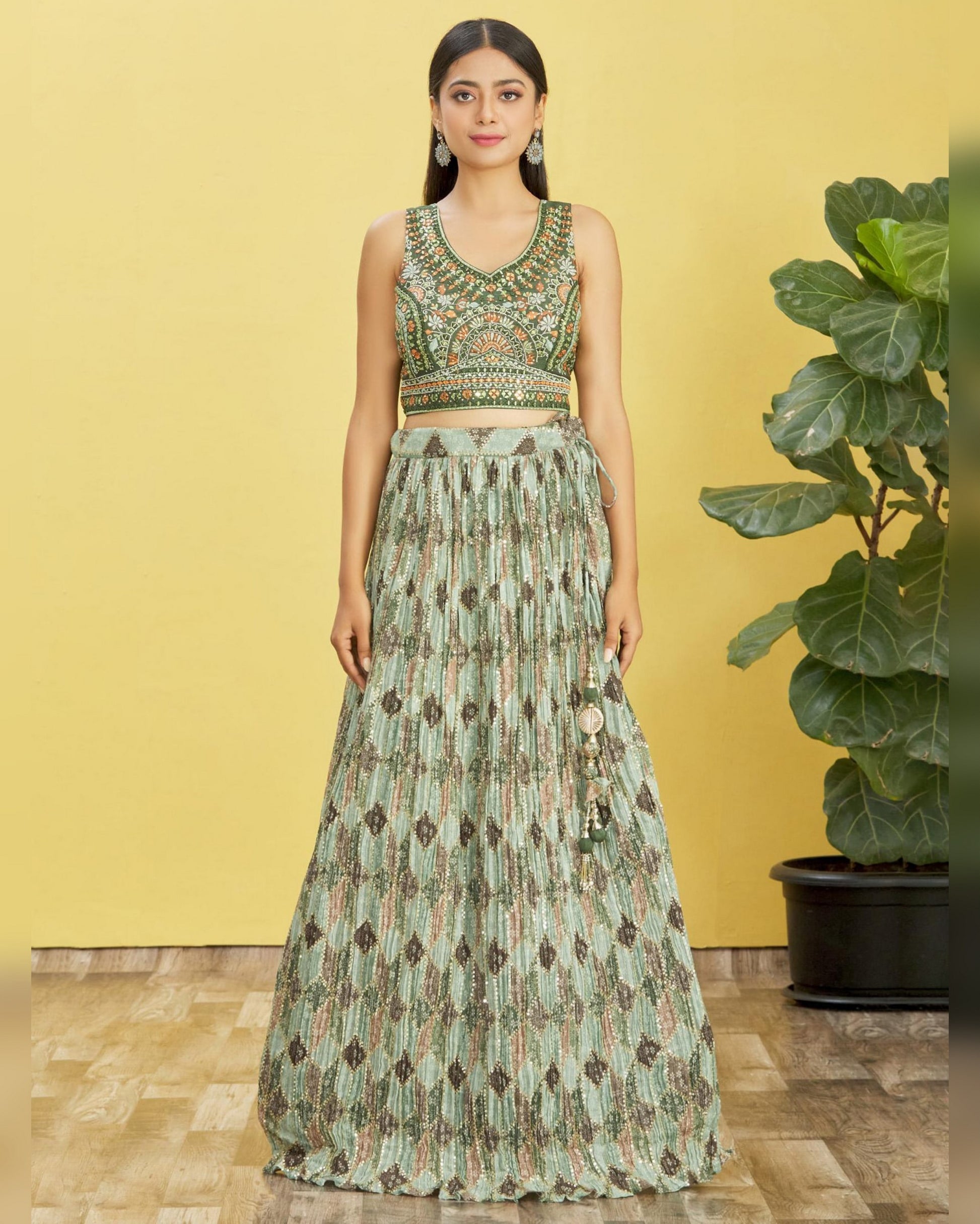 Woman wearing a green and brown patterned outfit against a yellow background