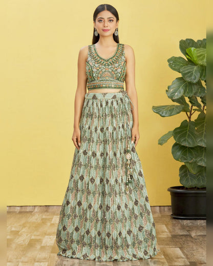 Woman wearing a green and brown patterned outfit against a yellow background