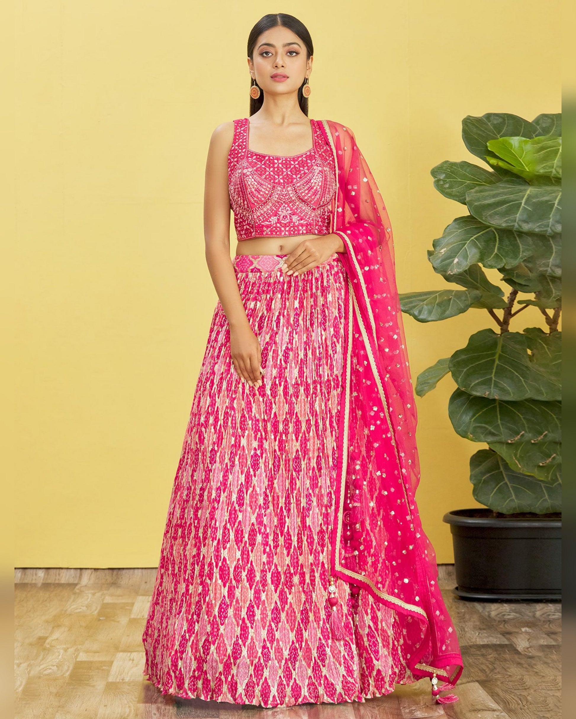 Woman wearing a pink and white patterned traditional outfit with a yellow background